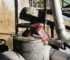 Orange Tag-Lok THO-3383 protective lockout/tagout holder securing a safety tag on industrial equipment in a dusty outdoor maintenance environment.